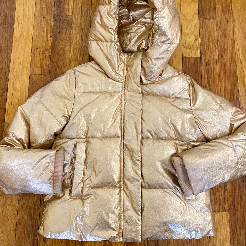 Gold puffer jacket. Attached hood.